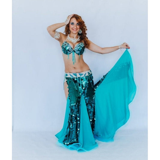 Woman in turquoise sequin belly dance costume with mermaid skirt and chiffon inserts